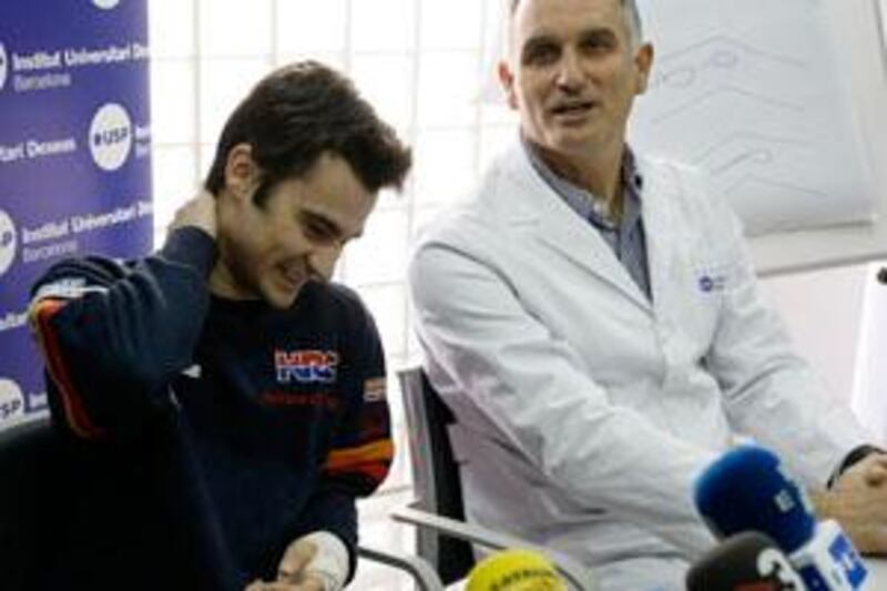 Moto GP Catalan rider Dani Pedrosa (L) listens to Dr. Xavier Mir's diagnosis during a news conference after two operations on his left knee and fractured left distal radius at USP Institut Universitari Dexeus in Barcelona March 7, 2009. Pedrosa will be out of action for three to four weeks after having three hours of surgery in Barcelona on the left knee and arm he injured in a crash in testing in Qatar on Monday. The Repsol Honda rider has undertaken just three complete days of testing so far this year, previously leaving the Sepang run-out a day early after complaining of a lack of recuperation in his knee (previously operated on in December).   REUTERS/Gustau Nacarino  (SPAIN SPORT MOTOR RACING) *** Local Caption ***  BAR08_MOTOGP-SPAIN-_0307_11.JPG