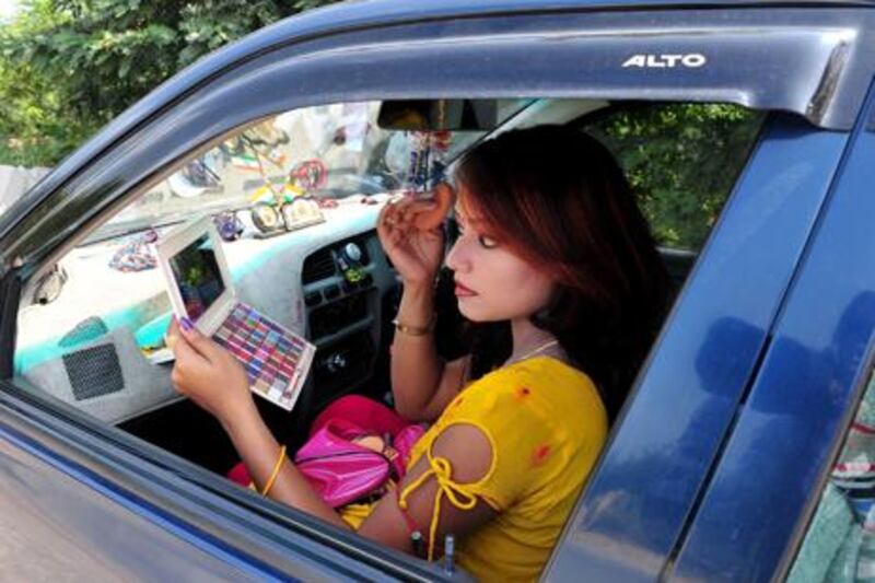 Jhollywood actress Varsha Lakra applies her make-up in her car on location before a shoot on the outskirts of Ranchi in Jharkhand. Manjunath Kiran / AFP