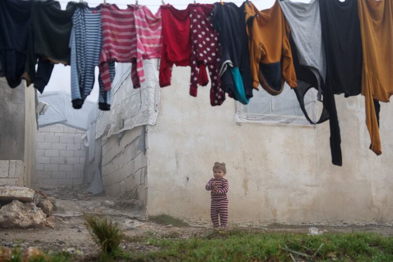 A child plays outdoors at a camp for internally displaced people in Al Zawf, north-western Syria. AFP