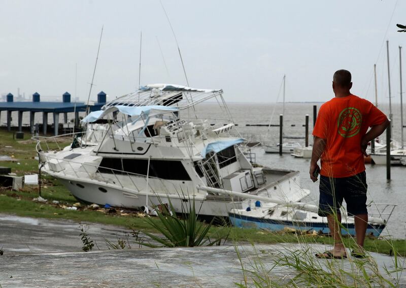 A man looks at boats damaged by Hurricane Harvey in Port Lavaca, Texas. Charlie Riedel / AP Photo