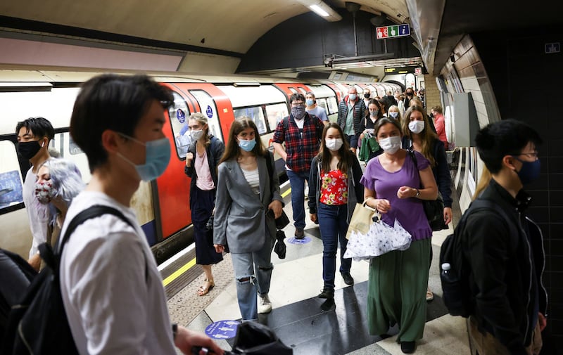 People walk along a platform on the London Underground.