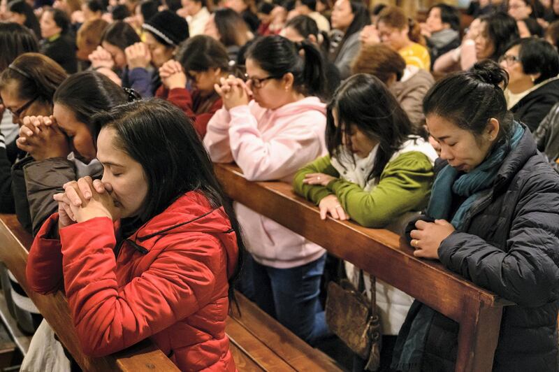 The congregation bow their heads in prayer. Finbar Anderson for The National