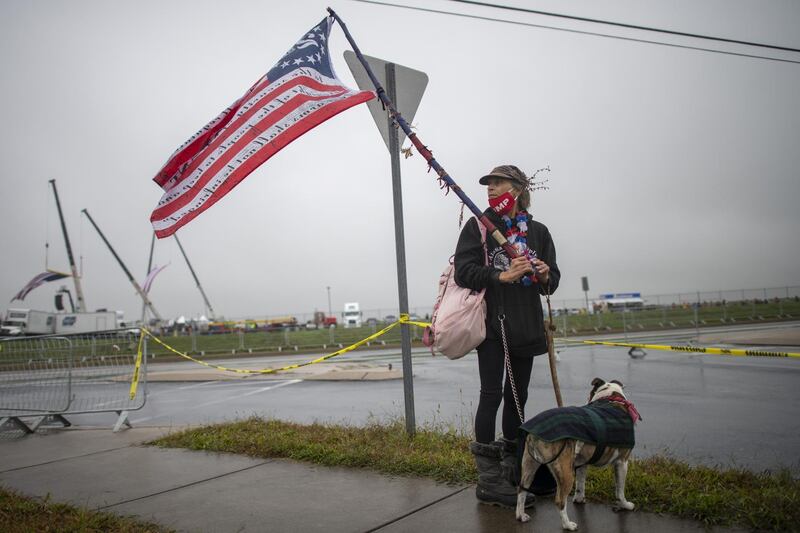 Karen Heck demonstrates with her dog outside the venue where President Donald Trump will hold a rally in Lititz, Pennsylvania. With 8 days to go before the election, Trump is holding 3 rallies across Pennsylvania, a crucial battleground state. AFP