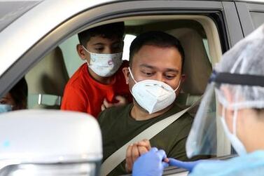 A medic tests a passenger in the back of a taxi at the drive-through screening centre at Mina Rashid in Dubai. Some malls in Dubai will no longer offer walk-in appointments. Chris Whiteoak / The National