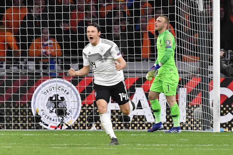 Germany's defender Nico Schulz (L) celebrates after scoring their third goal during the UEFA Euro 2020 Group C qualification football match between The Netherlands and Germany at the Johan Cruyff Arena in Amsterdam on March 24, 2019.  / AFP / EMMANUEL DUNAND
