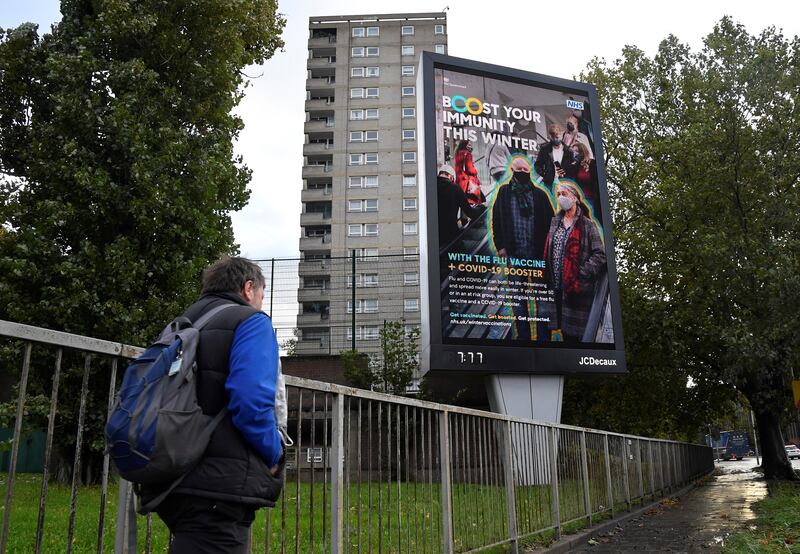 An NHS Covid-19 vaccination campaign advertisement near a housing block in London. Reuters