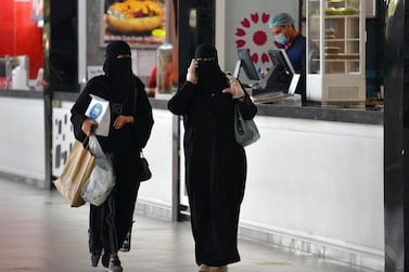 Women carry shopping bags and food they picked up from a restaurant in a mall in the Saudi capital Riyadh on June 4, 2020, after it reopened following the easing of some restrictions put in place by the authorities in a bid to stem the spread of the novel coronavirus. AFP