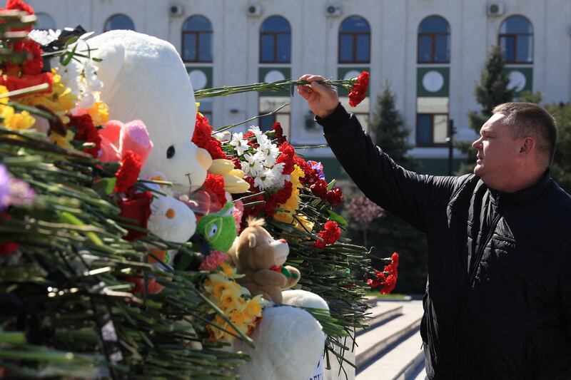A man lays flowers at a makeshift memorial in Simferopol, Crimea. AFP