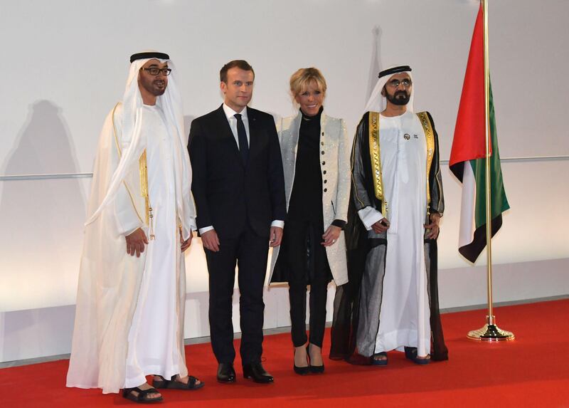 Sheikh Mohammed bin Rashid, right, and Sheikh Mohammed bin Zayed, left, pose at the entrance of Louvre Abu Dhabi with Mr and Mrs Macron during its inauguration.  Giuseppe Cacace / AFP Photo