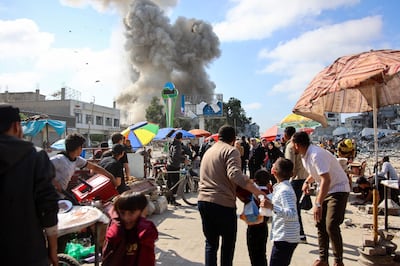 People react as an Israeli air strike hits the Firas market area of Gaza city on Thursday. AFP