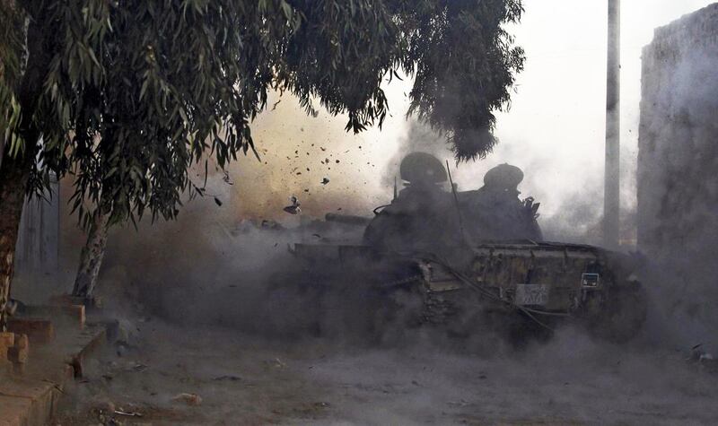 A Free Syrian Army tank fires a shell towards forces loyal to President Bashar Al Assad in Aleppo. An arm of the British defence consultant IHS Jane’s and experts at a nonprofit think tank in London estimate a couple of dozen Americans are fighting with rebels in Syria. Molhem Baraket / Reuters