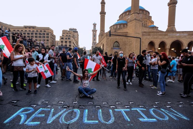 Protesters wave Lebanese flags shout anti-government slogans during a protest in central Beirut.  EPA