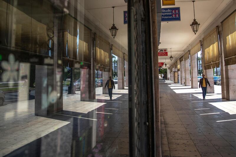 A man walks past empty shops during a state of emergency and home confinement orders due to coronavirus, in downtown Rabat, Morocco. AP Photo
