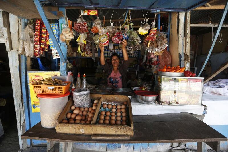 Lucia Liaza, 50, at her market stall where she sells food and spices in Gosen City. Liaza came from the violence-torn city of Ayacucho 20 years ago. She says that just recently has she been able to afford a few luxuries that she couldn’t previously. Mariana Bazo / Reuters