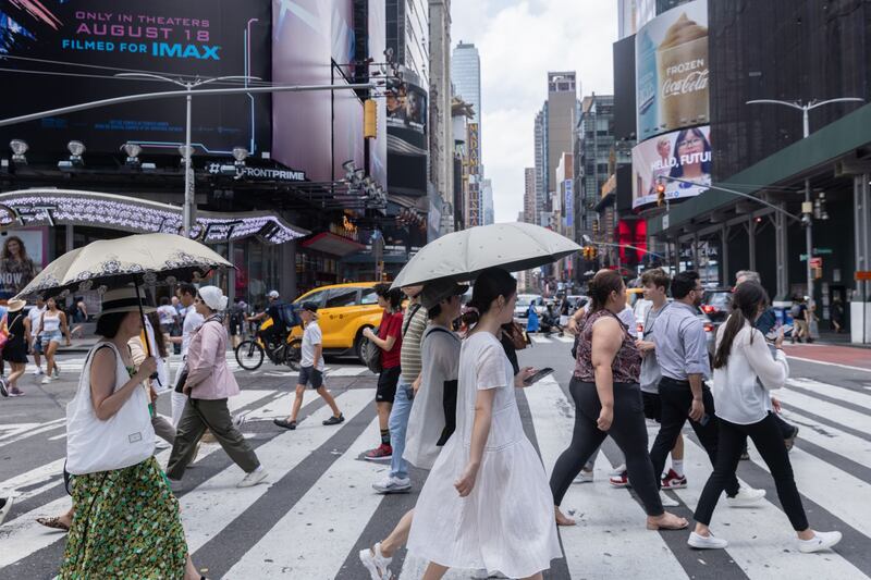 Pedestrians hold umbrellas for protection from the sun during a heat wave in New York, US. Bloomberg