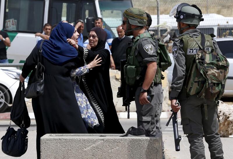 A Palestinian woman argues with an Israeli border policeman near the scene where a Palestinian mother of two and her brother where shot dead by Israeli forces near Qalandia checkpoint on  April 27, 2016. REUTERS/Ammar Awad