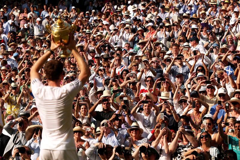 Fans cheer as Scotland's Andy Murray poses with the men's singles trophy in 2013, ending the UK's 77-year wait for a home-grown winner.