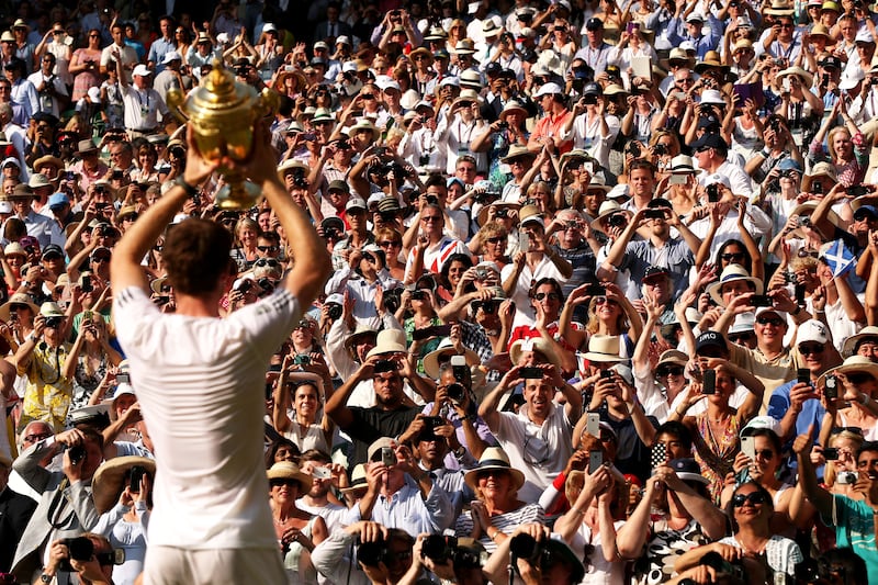 Fans cheer as Scotland's Andy Murray poses with the men's singles trophy in 2013, ending the UK's 77-year wait for a home-grown winner.