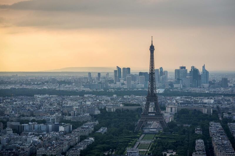 A picture taken on June 4, 2018 from the observatory deck of the Montparnasse tower in Paris, shows a view  the Eiffel tower and the Defense business district in background. / AFP / LUCAS BARIOULET
