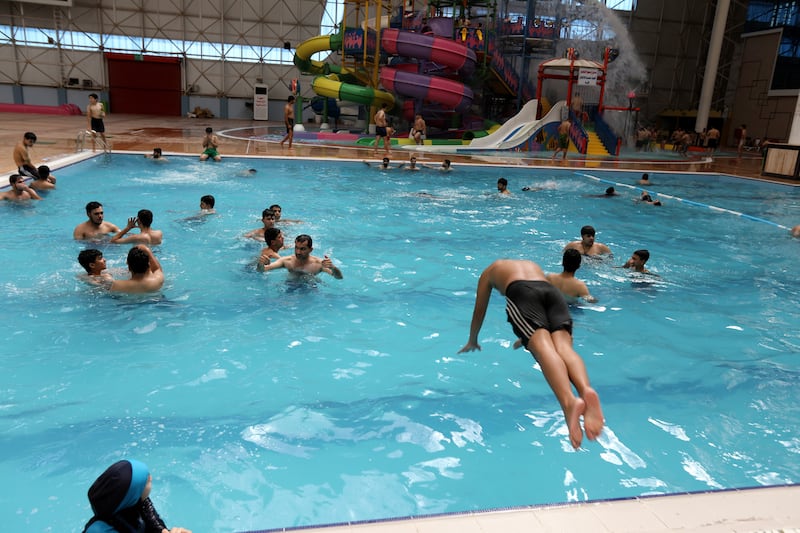 Iraqis keep cool at the aqua park in Sadr City. EPA