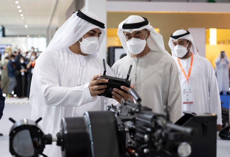 Sheikh Mohamed bin Zayed, Crown Prince of Abu Dhabi and Deputy Supreme Commander of the Armed Forces, examines an exhibit.
