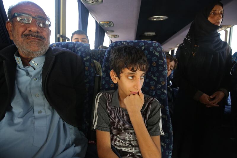 Iraqis sit in a bus transporting displaced families from the camp in Habbaniyah in Iraq's Anbar province. AFP