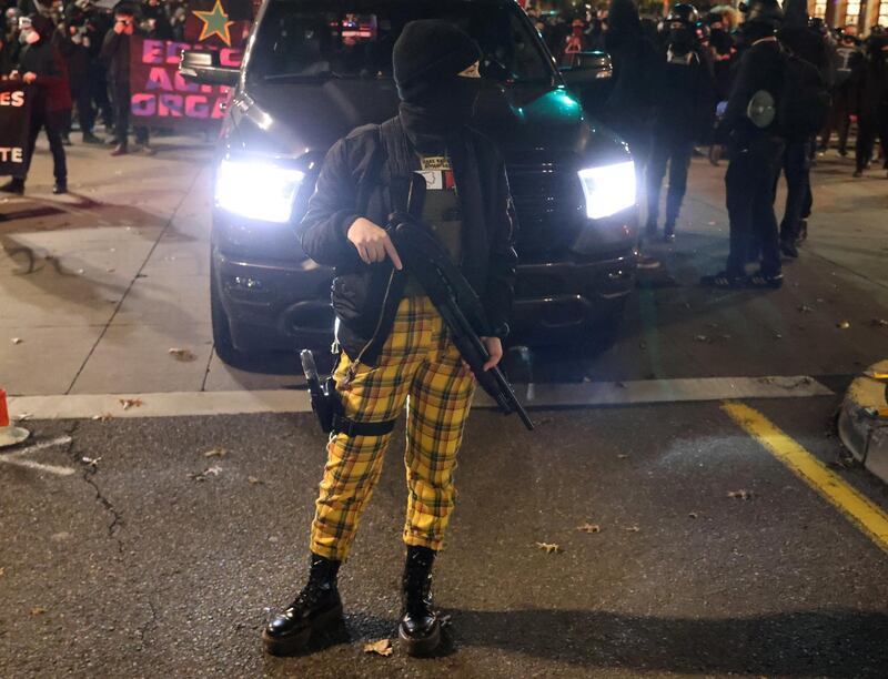 A female demonstrator carries weapons during a protest, the day after Election Day, in Portland, Oregon. Reuters