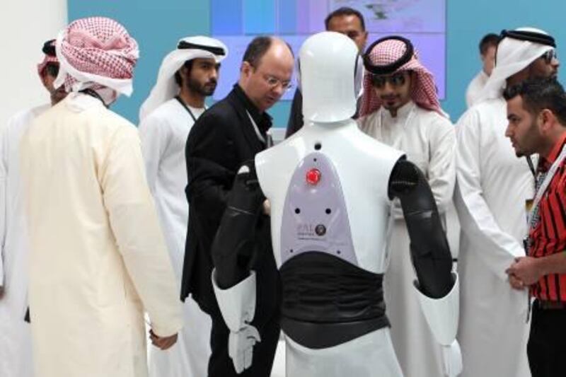 February 24, 2011 / Abu Dhabi / (Rich-Joseph Facun / The National) Men observe a robot at the International Defence Exhibition and Conference, Thursday, February 24, 2011 in Abu Dhabi.