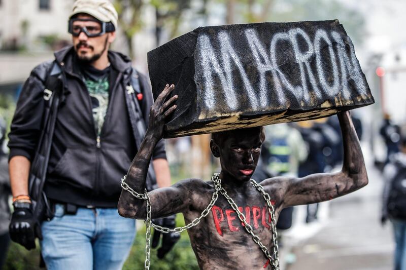 A protester made up as a slave targets president Emmanuel Macron' during the demonstration on International Workers' Day. EPA/CHRISTOPHE PETIT TESSON