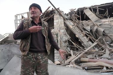 A man stands near what is left of his neighbour's house, which was hit by shelling in Stepanakert, the capital of Nagorno-Karabakh. AP