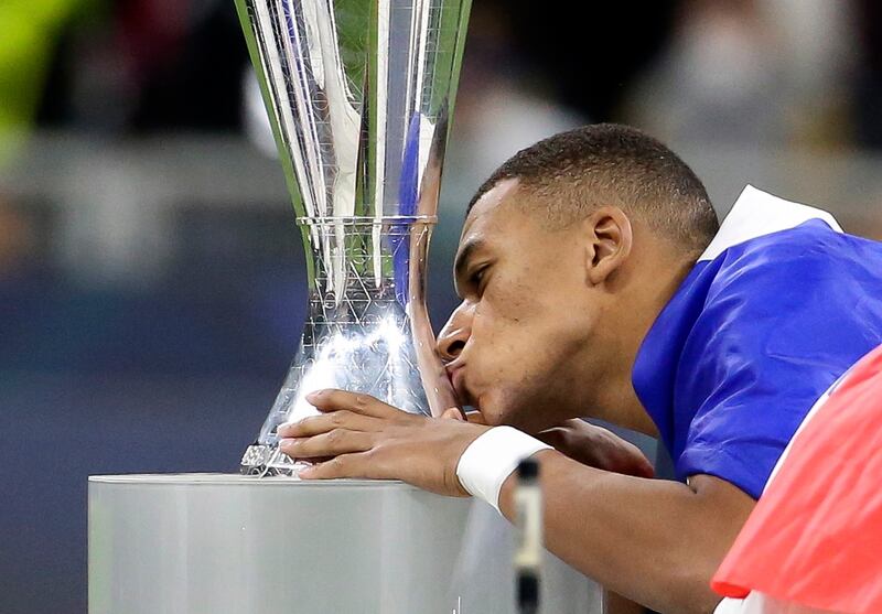 France's Kylian Mbappe kisses the trophy. EPA