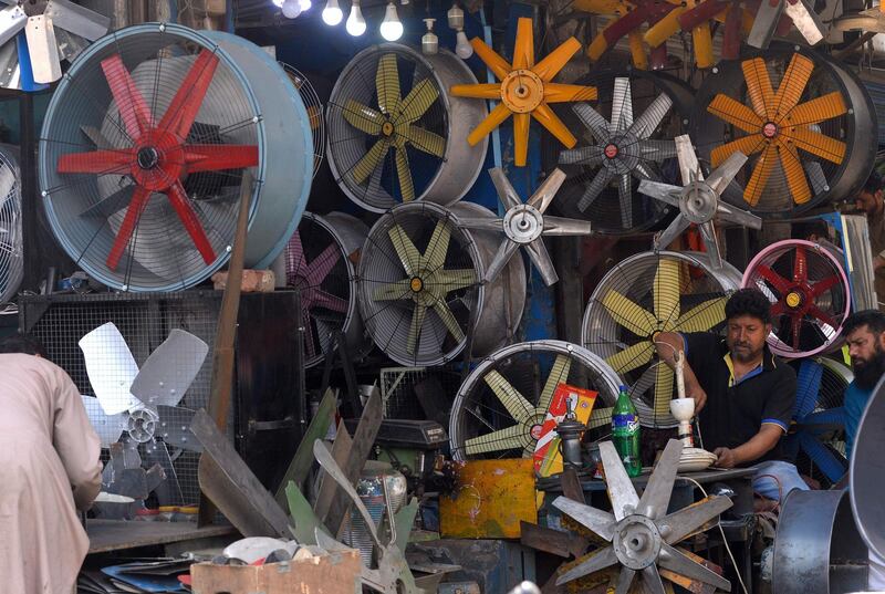 A Pakistani man repairs a fan at his workshop in Lahore. AFP