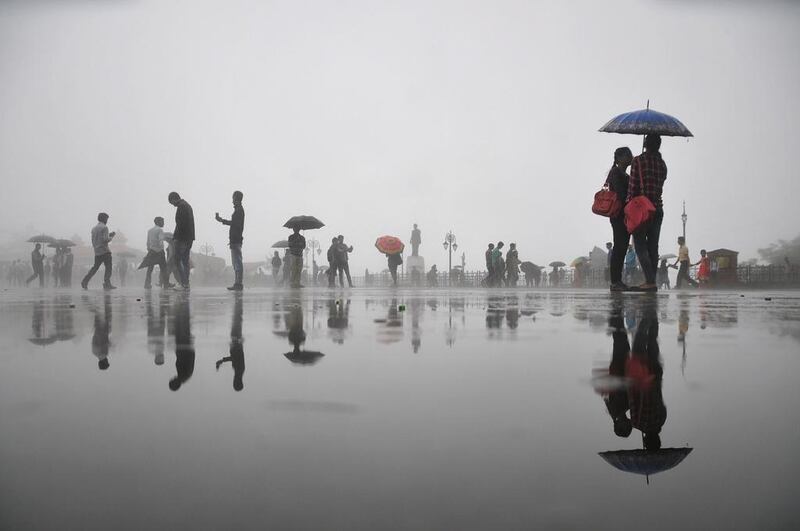 Pedestrians walk with umbrellas during rainfall in Shimla.  STR / AFP