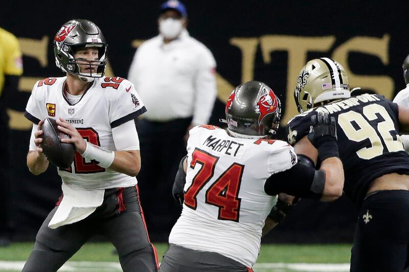 Tampa Bay Buccaneers quarterback Tom Brady (12) works in the pocket as New Orleans Saints defensive end Marcus Davenport (92) applies pressure during the first half of an NFL divisional round playoff football game, Sunday, Jan. 17, 2021, in New Orleans. (AP Photo/Butch Dill)