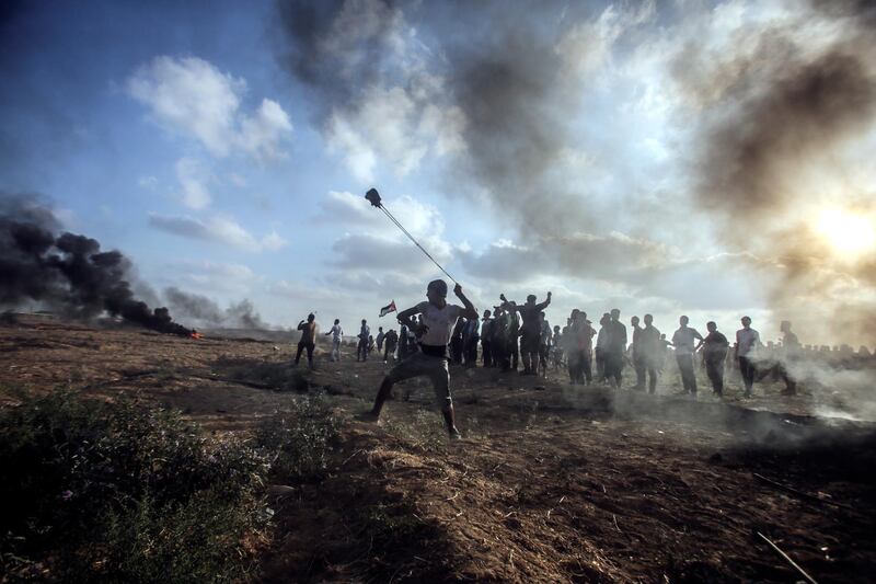 Palestinians take part during the clashes between Israeli troops and Palestinians near the border in the east Gaza City on July 13. EPA