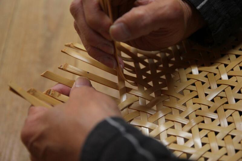 Weaving bamboo strips at the bamboo weaver Chifuyu Enomoto's studio. Kohei Yonezawa / The Art of Travel