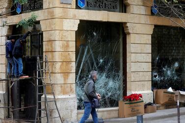 A man walks past a damaged bank in Beirut. The country is facing an unprecedented wave of public protest that began in October last year. Reuters