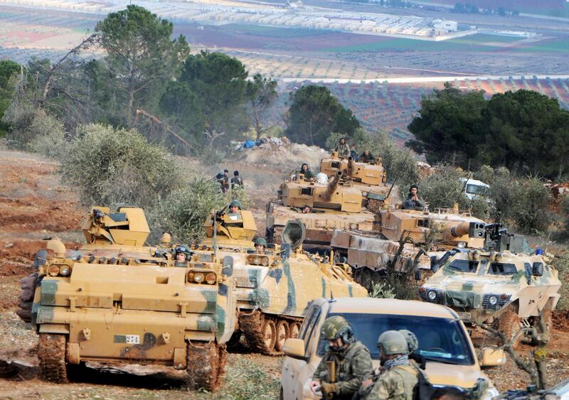 FILE - This Jan. 28, 2018 file photo, Turkish troops take control of Bursayah hill, which separates the Kurdish-held enclave of Afrin from the Turkey-controlled town of Azaz, Syria. Nearly a month into Turkey's offensive in the Syrian Kurdish enclave of Afrin, hundreds of thousands of Syrians are hiding from bombs and airstrikes in caves and basements, trapped while Turkish troops and their allies are bogged down in fierce ground battles against formidable opponents. (DHA-Depo Photos via AP, File)