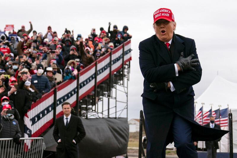 President Donald Trump jokes about the cold as he arrives for a campaign rally at Michigan Sports Stars Park, Sunday, November 1, 2020, in Washington, Michigan. AP Photo