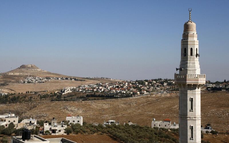 The minaret of a mosque stands on the foreground as the Israeli settlement of Tekoa (C) is pictured on November 19, 2019 near the Palestinian West Bank town of Bethlehem.  Israeli Prime Minister Benjamin Netanyahu said a US statement deeming Israeli settlement not to be illegal "rights a historical wrong". But the Palestinian Authority decried the US policy shift as "completely against international law". Both sides were responding to an announcement by US Secretary of State Mike Pompeo saying that Washington "no longer considers Israeli settlements to be "inconsistent with international law". / AFP / HAZEM BADER
