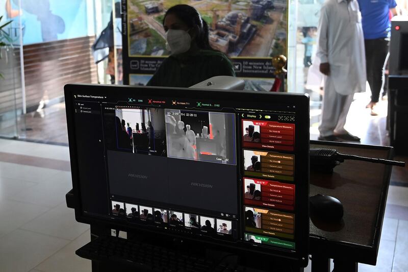 In this picture taken on May 18, 2020 a shopping mall official (unseen) uses a thermal scanner to check the temperature of shoppers before they enter at the Centaurus Mall after the government eased a nationwide lockdown imposed as a preventive measure against the COVID-19 coronavirus, in Islamabad. 
 Pakistan's intelligence agencies are using secretive surveillance technology they initially deployed to locate militants to instead track people who have tested positive for the new coronavirus, officials told AFP.
 - TO GO WITH: health virus Pakistan technology, FOCUS By Nasir JAFFRY
 / AFP / Aamir QURESHI / TO GO WITH: health virus Pakistan technology, FOCUS By Nasir JAFFRY
