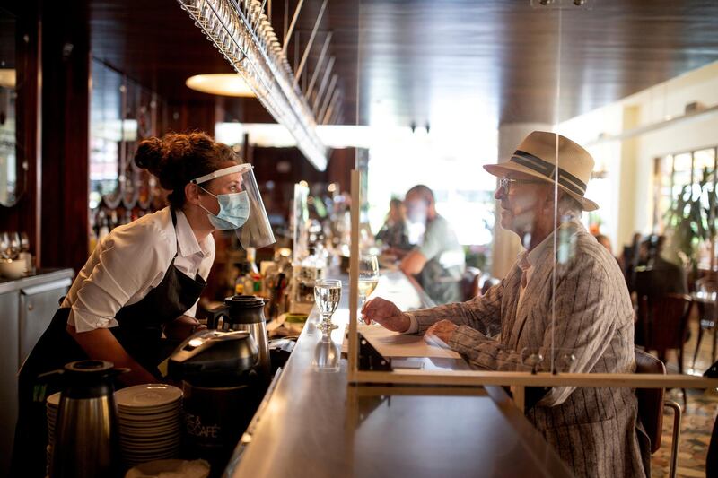 A bartender talks to a patron at Lemeac restaurant on the first day after the coronavirus restrictions were lifted to visit restaurants in Montreal, Quebec, Canada, on June 22. Christinne Muschi/ Reuters