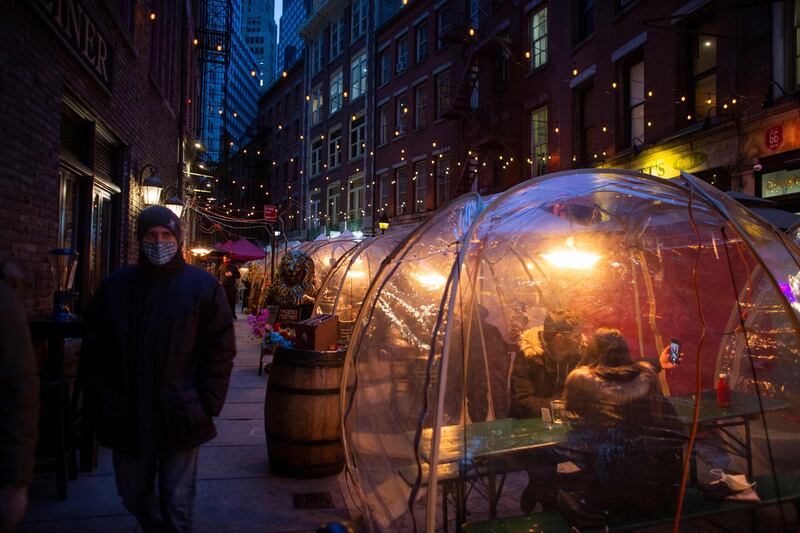A couple sits at a 'Private Snow Globe' as they celebrate Valentine's day at Magical pub The Cauldron in New York. AFP