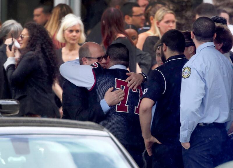 Mourners console each other during the funeral service for Marjory Stoneman Douglas High School assistant football coach, Aaron Feis. at the Church by the Glades in Coral Springs, Fla., Thursday, Feb. 22. 2018. Football players wearing Stoneman Douglas jerseys carried Feis' casket into the service at the church where family and friends gathered to remember him as loyal and caring. (Mike Stocker/South Florida Sun-Sentinel via AP)