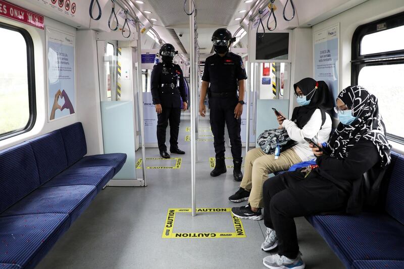 Auxiliary police officers wearing 'Smart Helmet', a portable thermo-scanner that can measure the temperature of passengers at a distance, patrol inside a commuter train, amid the coronavirus outbreak in Kuala Lumpur, Malaysia. Reuters