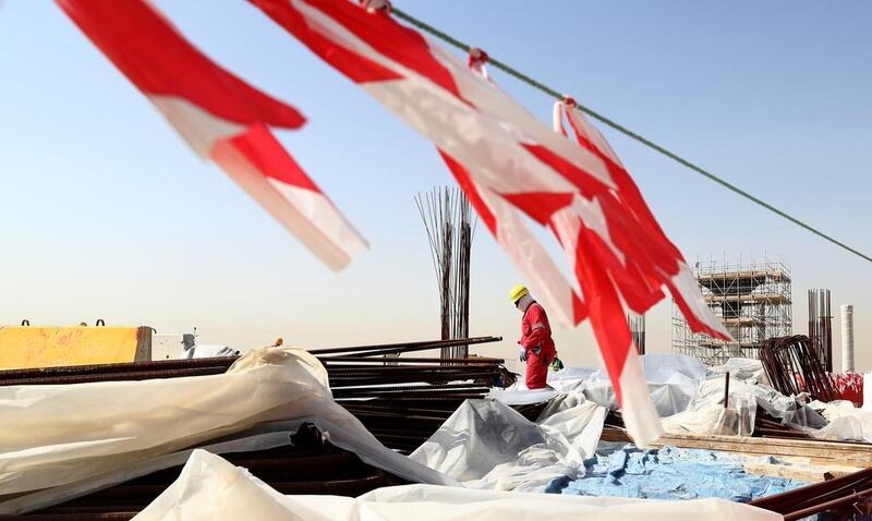 Above, workers at the 60,000-seat Al Bayt stadium, which is due for completion next year. Lars Baron / Bongarts / Getty Images