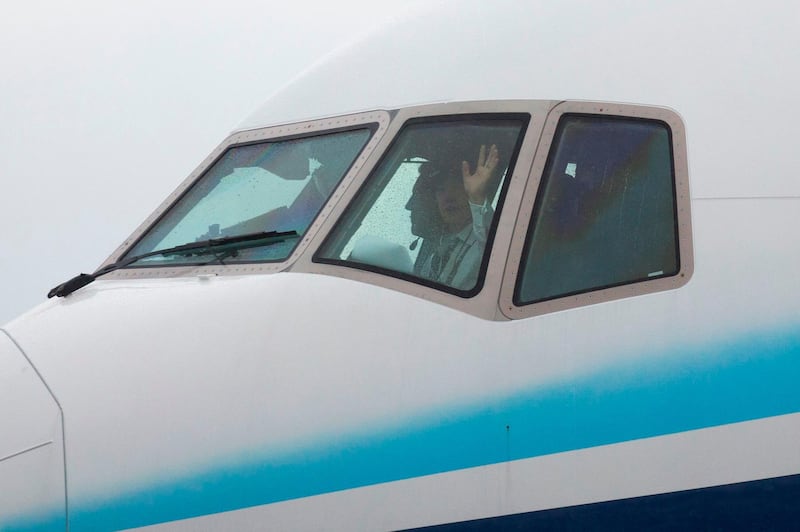 A pilot in the Boeing 777X airplane waves as it taxis for the first flight. AFP