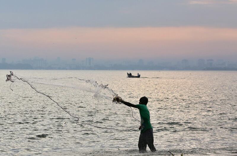 A fisherman casts his net as pre-monsoon clouds gather over the Arabian Sea in Kochi, India. Sivaram V / Reuters