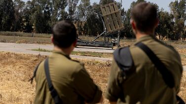 Israeli soldiers stand near an Iron Dome battery near the border with the Gaza Strip. Getty Images