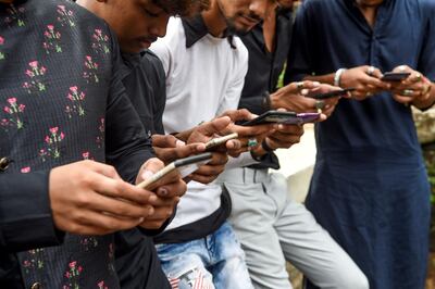 In this photo taken on November 10, 2019, youngsters watch videos on video-sharing app TikTok on their mobile phones in Mumbai. He's no Bollywood superstar, but Israil Ansari can barely walk down a street in India without teenagers flocking to him for autographs -- thanks to TikTok, the addictive and controversial app on which he has two million followers. / AFP / Indranil MUKHERJEE / TO GO WITH AFP STORY India-TikTok-video-science-internet,FOCUS by Vishal MANVE

